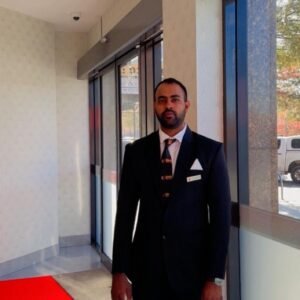Qwik Security corporate concierge officer in a suit at a building entrance