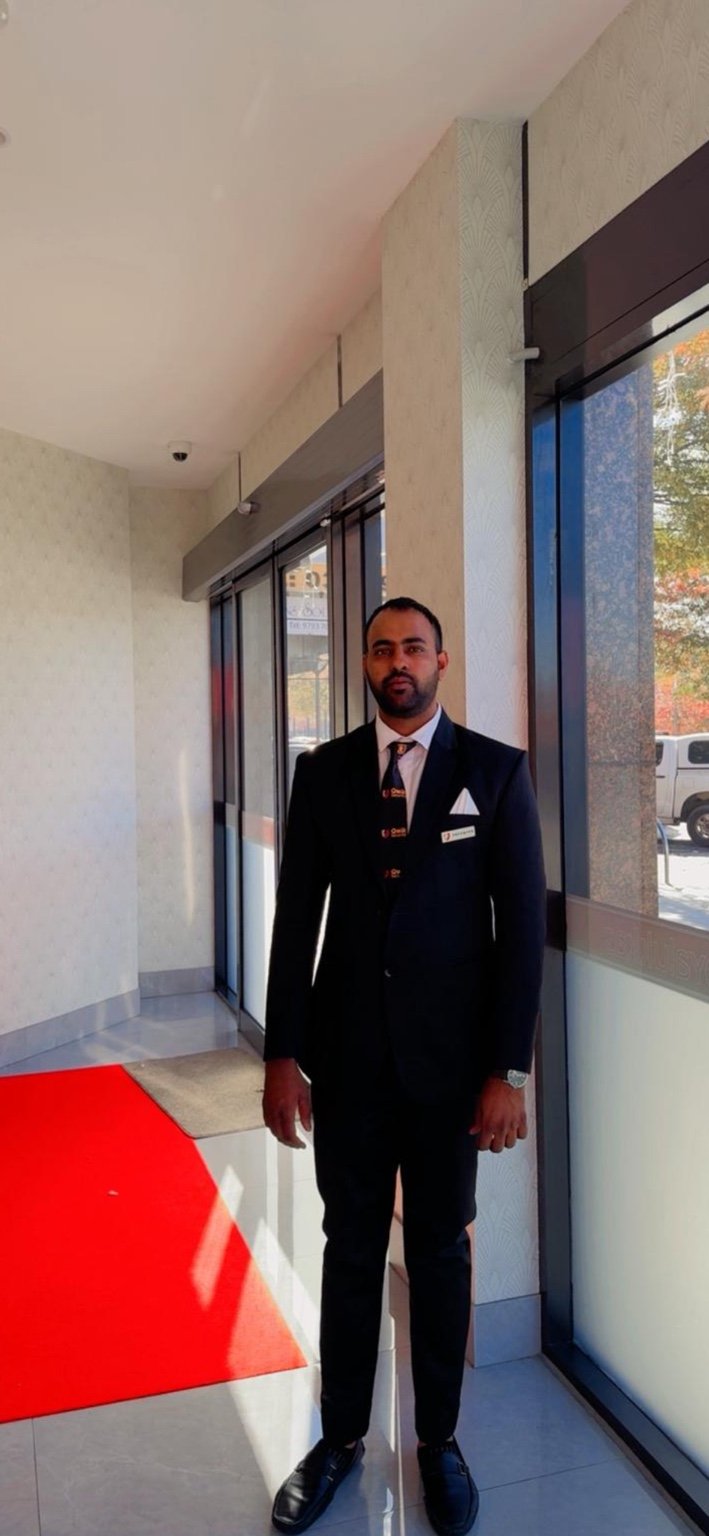 Qwik Security corporate concierge officer in a suit at a building entrance