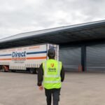 Qwik Security warehouse security guard outside loading bays with a Direct Freight Express truck visible