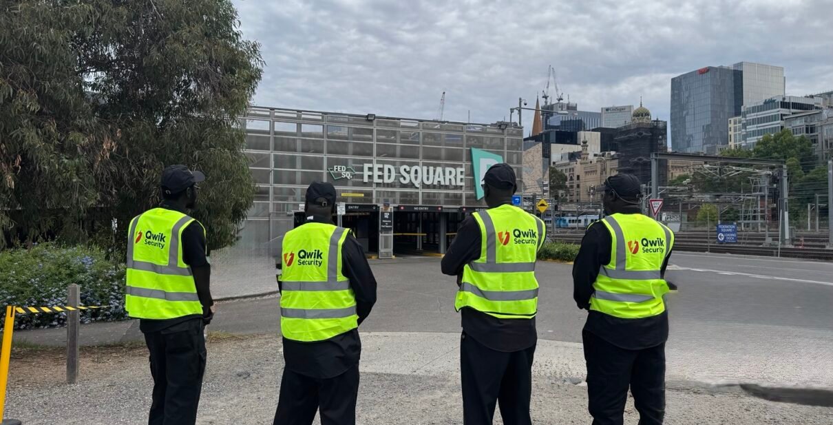 Four Qwik Security event guards in high-visibility vests at Federation Square, Melbourne