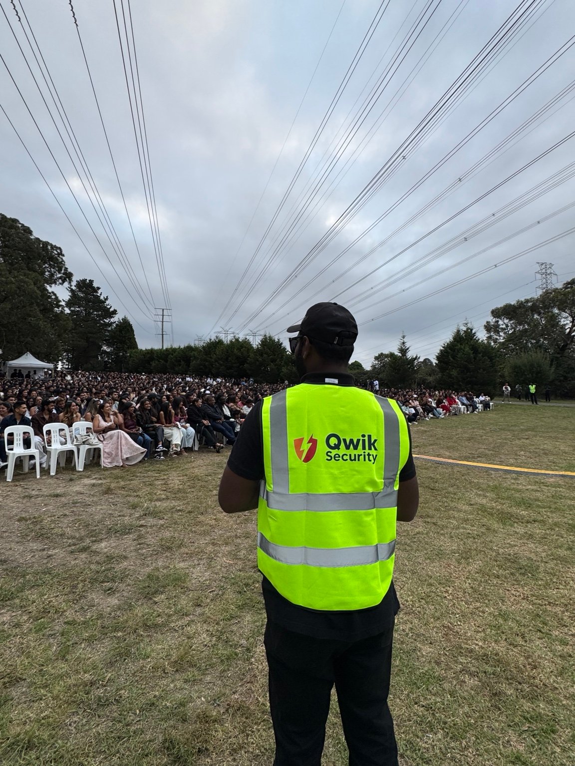 Qwik Security static guard in a high-visibility vest monitoring an outdoor event