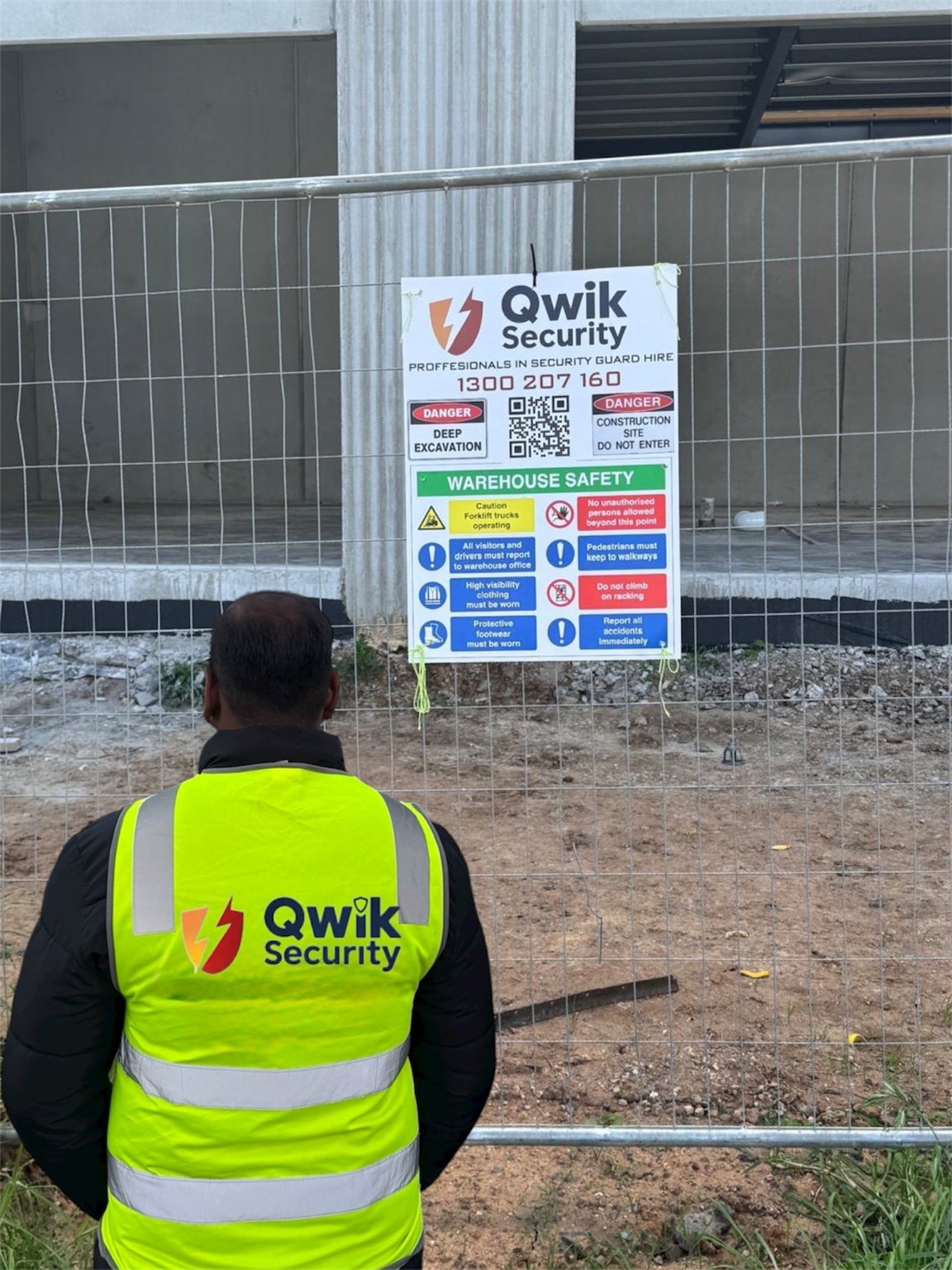 Qwik Security guard in a high-visibility vest at a fenced construction site