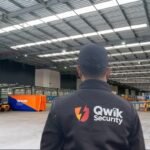 Qwik Security static guard inside a warehouse with forklifts and warehouse operations visible